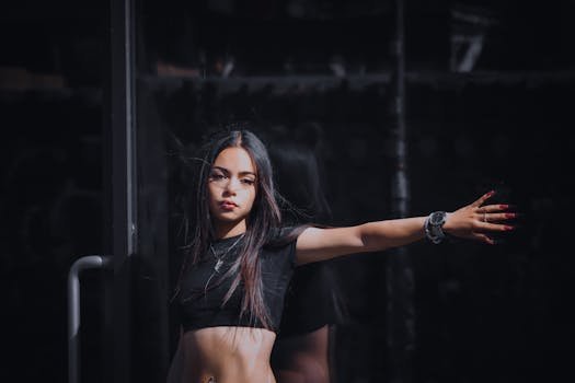 Elegant young woman posing outdoors with striking fashion in dark tones, exuding confidence.