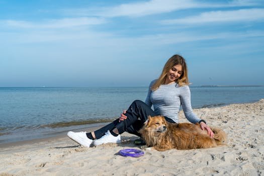 Woman enjoying a sunny day at Kołobrzeg beach with her dog, capturing a perfect seaside moment.