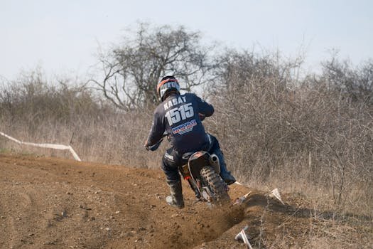 Rider on motocross bike takes on a challenging dirt track in Jihomoravský kraj, Česko.